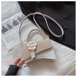 Détail du sac à main patchwork beige avec fermoir pétale doré et poignée incurvée chic