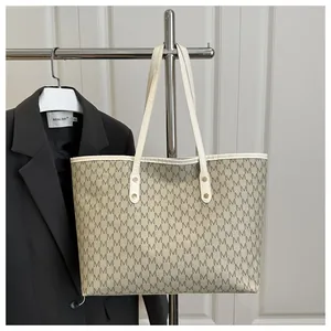 Detail of vintage monogram tote bag hanging with white leather handles and rivets