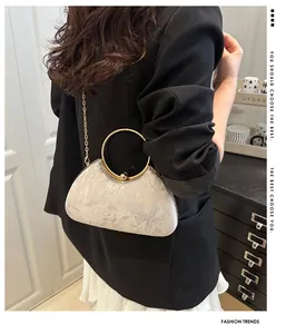 Detail of silver evening clutch with floral embroidery and golden metal round handle