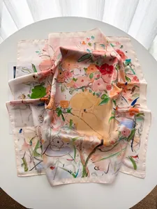 Gros plan d'un foulard en soie avec imprimé floral de peinture à l'huile sur une table blanche