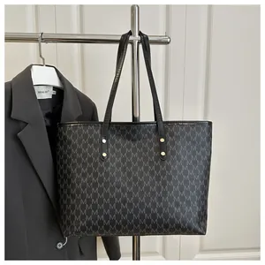 Close-up of vintage large tote bag with M-pattern print and golden rivets detailing