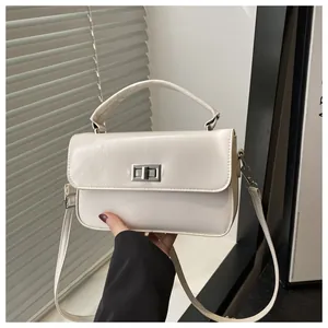 Detailed view of cream PU leather crossbody bag with silver twist lock and pebble texture