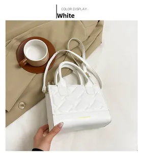 Detail van witte crossbodytas met gewatteerde stiksels en FASHION & BAGS opdruk