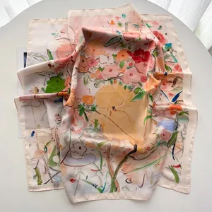 Détail d'un foulard carré soyeux avec des illustrations de fleurs et animaux mignons