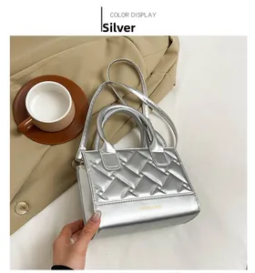 Detail van zilveren gewatteerde crossbodytas met FASHION & BAGS tekst en handvat