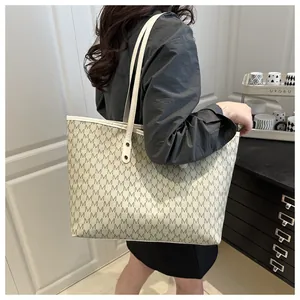 Detail of large vintage tote bag with M-letter monogram pattern shown on shoulder