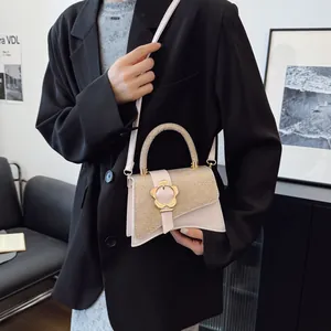 Sac à bandoulière beige chic avec patchwork pailleté doré et fermoir fleuri sur modèle