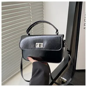 Close-up of the silver metal swivel lock and glossy leather texture on a black bag