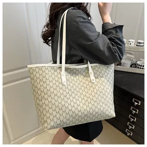 Detailed view of large tote bag featuring vintage M-letter monogram print and long straps