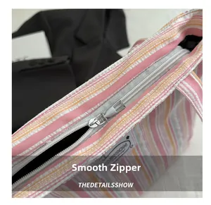 Détail du zip métallique fluide et de la toile à rayures colorées du sac cabas