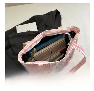 Détail montrant la grande capacité du sac fourre-tout en toile rayé avec des livres