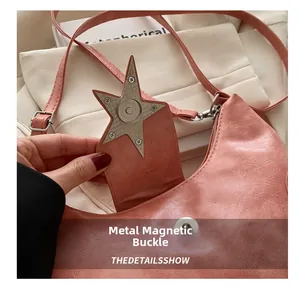 Dettaglio della borsa in pelle increspata rosa con chiusura magnetica in metallo a stella
