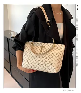 Detail of off-white monogram tote bag with gold hardware and metal deer pendant