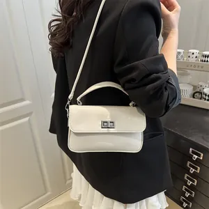 Minimalist cream white square crossbody bag with silver turn-lock and top handle