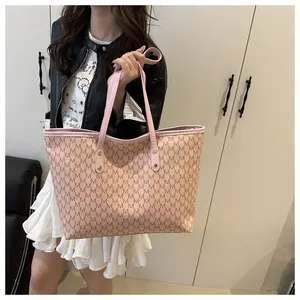 Detail view of large pink tote bag with M-pattern print on a model in home setting