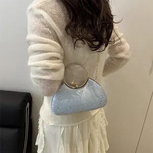 Light blue evening clutch bag with floral relief texture and golden ring handle