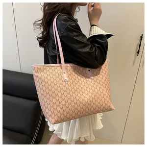 Detail of vintage large tote bag with M-letter monogram print and gold rivet hardware