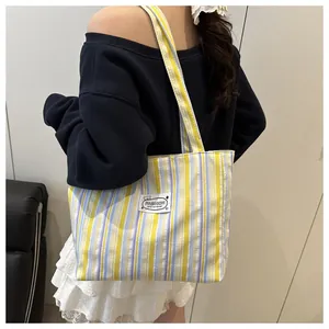 Vue détaillée du dos d'un sac cabas en toile rayée montrant l'étiquette et la texture