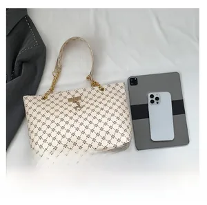 Capacity detail of tote bag with metal chain strap and golden deer pendant showing internal space
