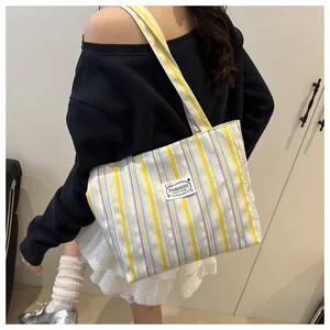 Détail d'un sac cabas en toile à rayures colorées avec étiquette mode et texture fine