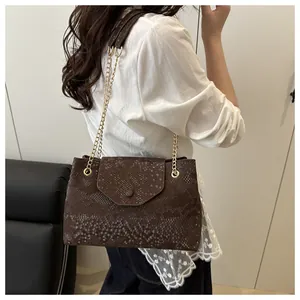 Vue latérale du sac marron foncé avec motif serpent et bandoulière en chaîne dorée