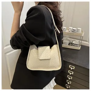 Vue détaillée de la texture tressée du sac hobo crème et de sa fine bandoulière réglable