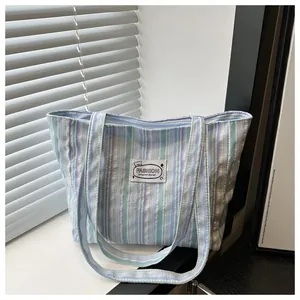 Détail du cabas en toile à rayures avec étiquette de logo d'ours à la mode