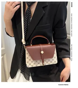 Detail of vintage clover pattern bag with gold rotary lock and cream shoulder strap