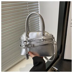 Dettaglio della borsa a mano argento con design a cinturini incrociati e fibbia