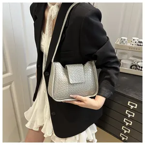 Détail de la texture tissée métallisée argentée et silhouette en U du sac à bandoulière