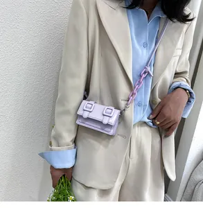 Close-up of lavender mini crossbody bag with matching thick chain strap on model
