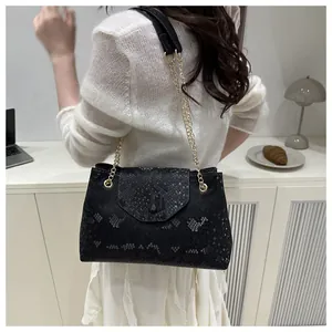 Vue arrière du sac à bandoulière noir à motif serpent porté avec une tenue en tricot