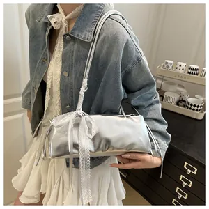 Close-up of silver metallic shoulder bag featuring a white lace bow in balletcore style