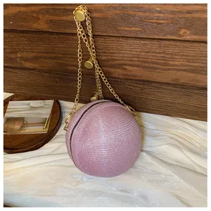 Macro view of pink glitter spherical evening bag with golden chain strap and ball clasp