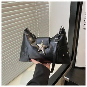Dettaglio della borsa punk nera con stelle metalliche argentate e fibbie regolabili