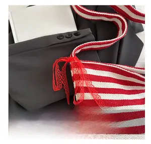 Detail of red and white striped knit tote bag featuring a red lace bow decoration