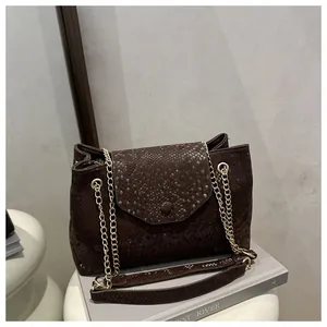 Détail du sac marron foncé à motif serpent avec chaîne dorée et boucle métallique chic