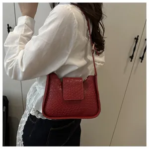 Détail du sac à bandoulière rouge foncé avec texture tissée et boucle en métal haut de gamme