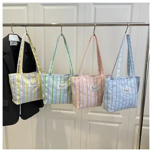 Vue détaillée de quatre sacs cabas en toile à rayures colorées sur un présentoir