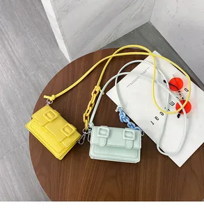 Detail view of yellow and mint green mini satchel bags with chunky plastic chains