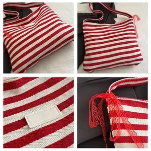 Detail view of red and white striped canvas tote bag with lace ribbon and leather patch