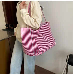 Detailed view of red and white striped canvas tote bag with functional exterior pocket