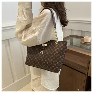 Detail of dark brown tote bag with retro diamond pattern and gold deer charm