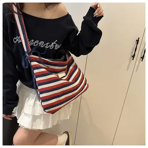Detail of striped canvas tote bag with lace bow decoration and comfortable shoulder strap