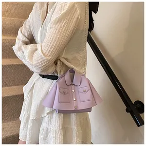 Detail of lavender jacket-shaped handbag with silver chain strap on white dress
