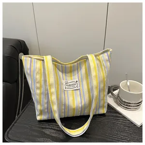 Bolso tote grande de lona con rayas verticales amarillas y azul claro y asas anchas