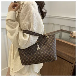 Brown tote bag with diamond pattern and gold deer charm shown on model's shoulder