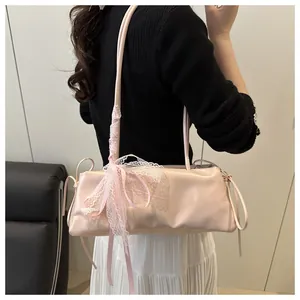 Detail of pink faux leather baguette bag with lace bow decoration on a shoulder strap