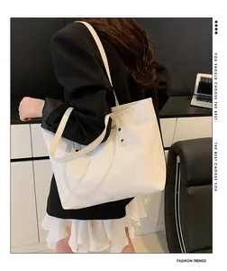 Detail shot of white nylon tote bag showing textured fabric and reinforced black rivets