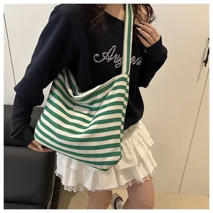 Detail of green and white striped canvas tote bag showing the thick fabric texture and strap